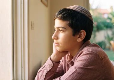 נער בפרופיל מקשיב, סנטר נשען על כף היד